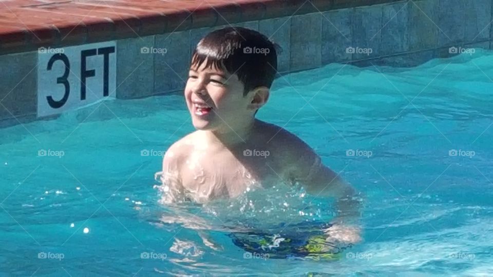 Happy boy enjoying swimming pool