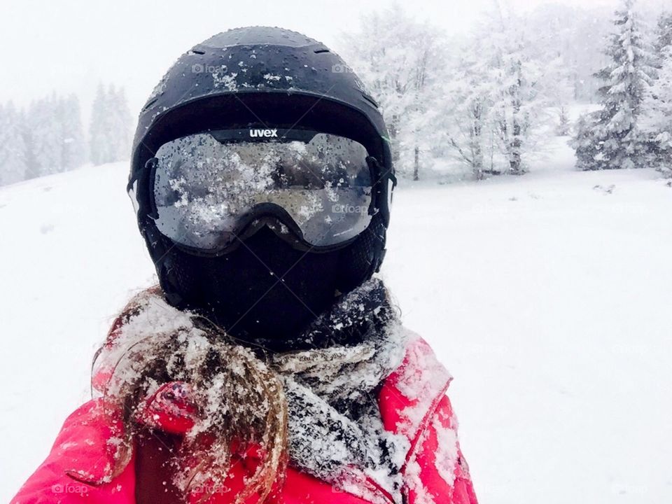 Woman skier with frozen ski glasses,frozen ski helmet,frozen hair and frozen jacket