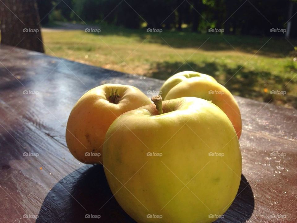 Three apples on a wooden table. 