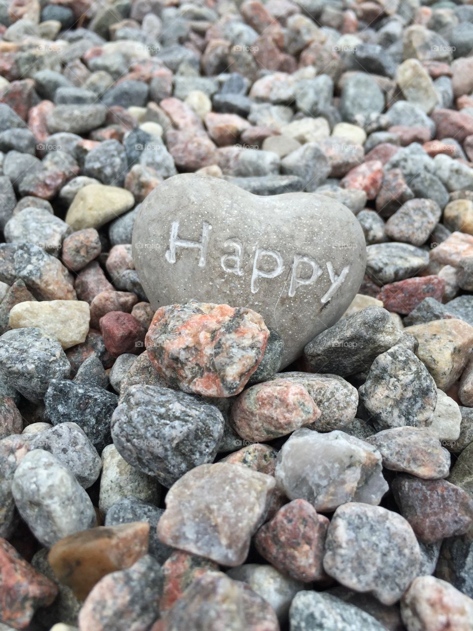 Happy text on heart shape rock