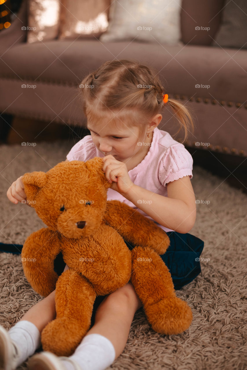 girl playing with a bear