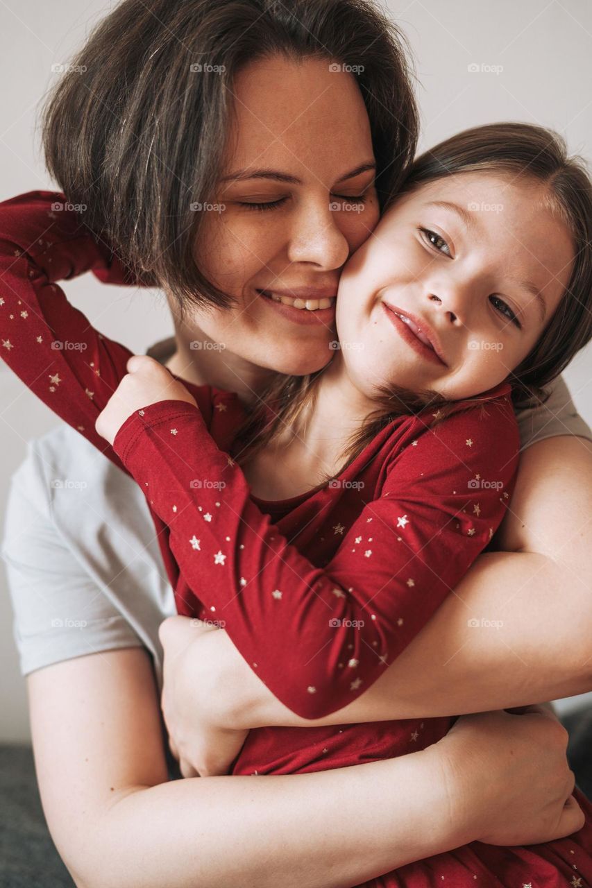 Close up portrait of happy Mom and daughter together at the home