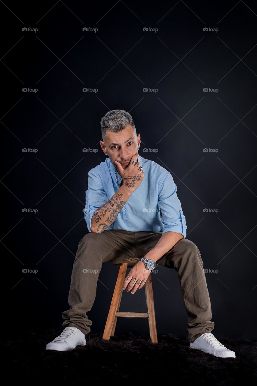 Rapper com tatoo sentado