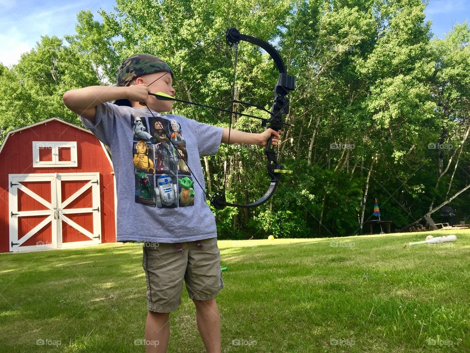 Boy shooting bow and arrow