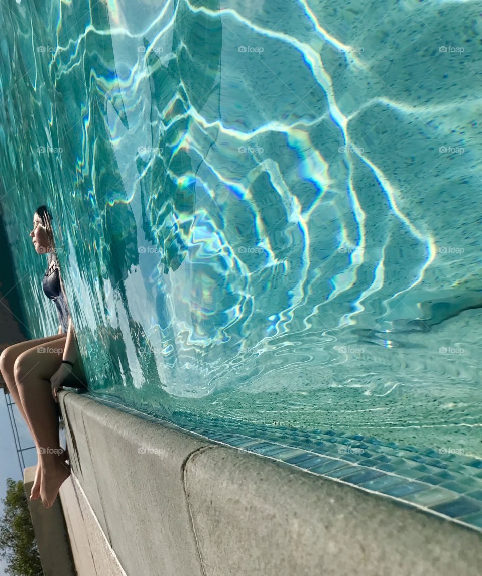 Girl sitting on the edge of the pool