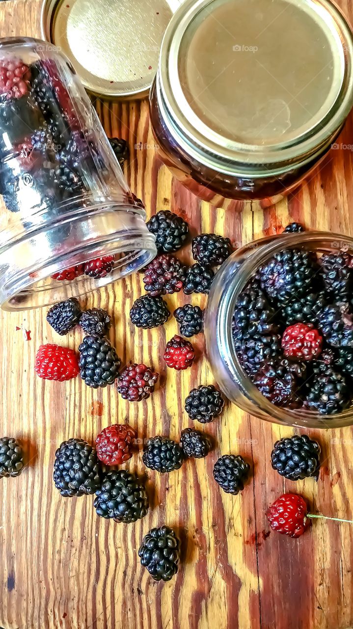 wild berries in jars on wood cutting board