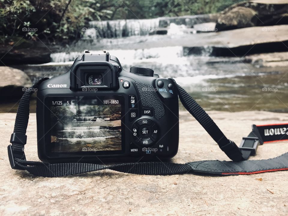 A picture of a camera and waterfall. 