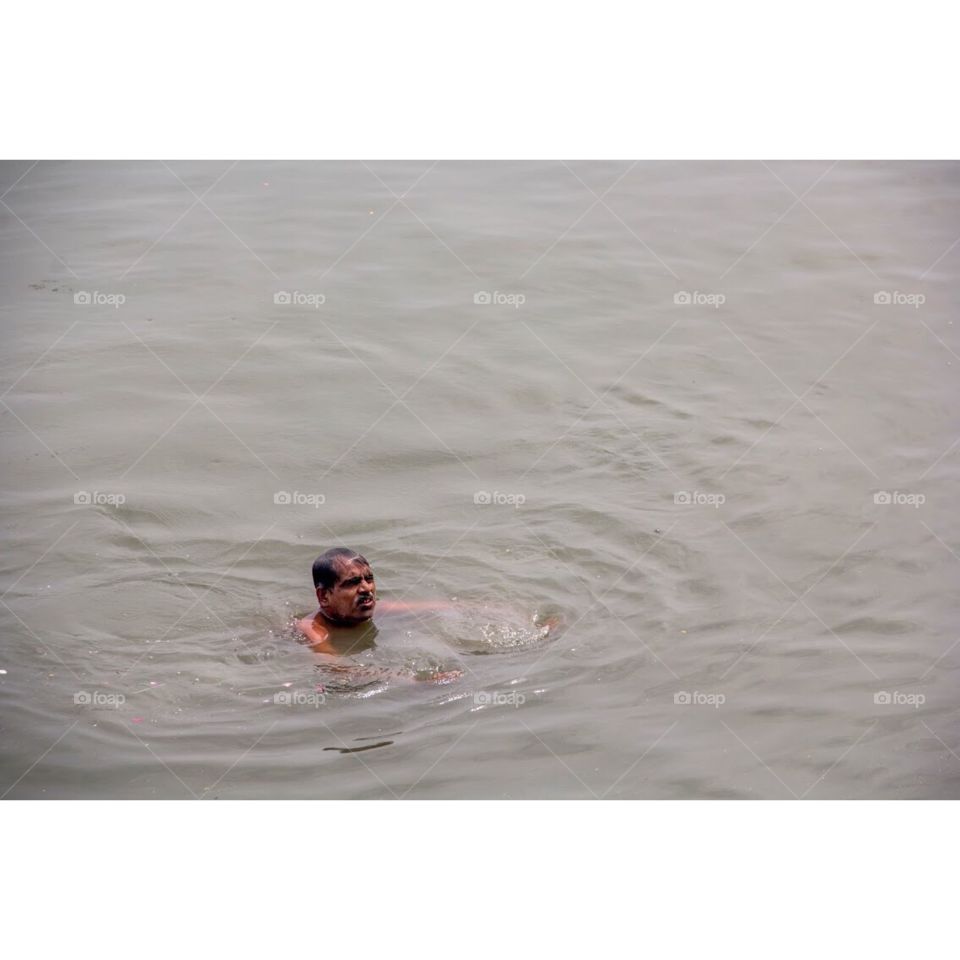 Old man swimming in lake holi 