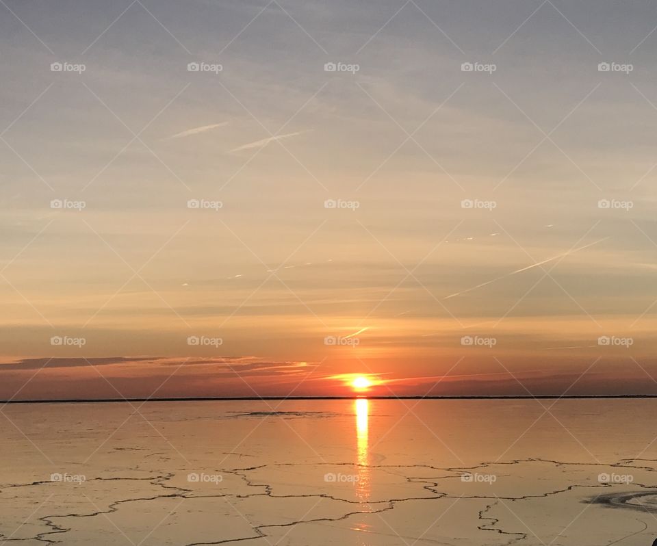 Sunrise reflections on frozen lake