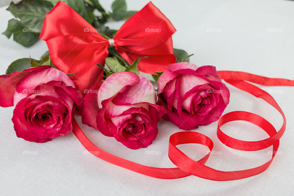 a bouquet of red roses and red bow