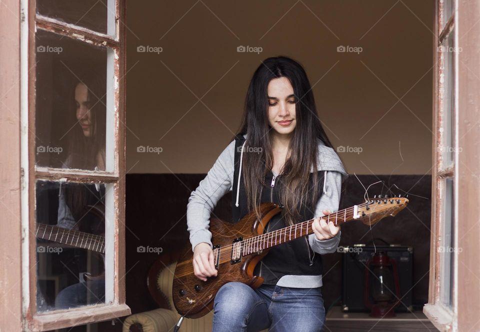 Woman playing a guitar on the window