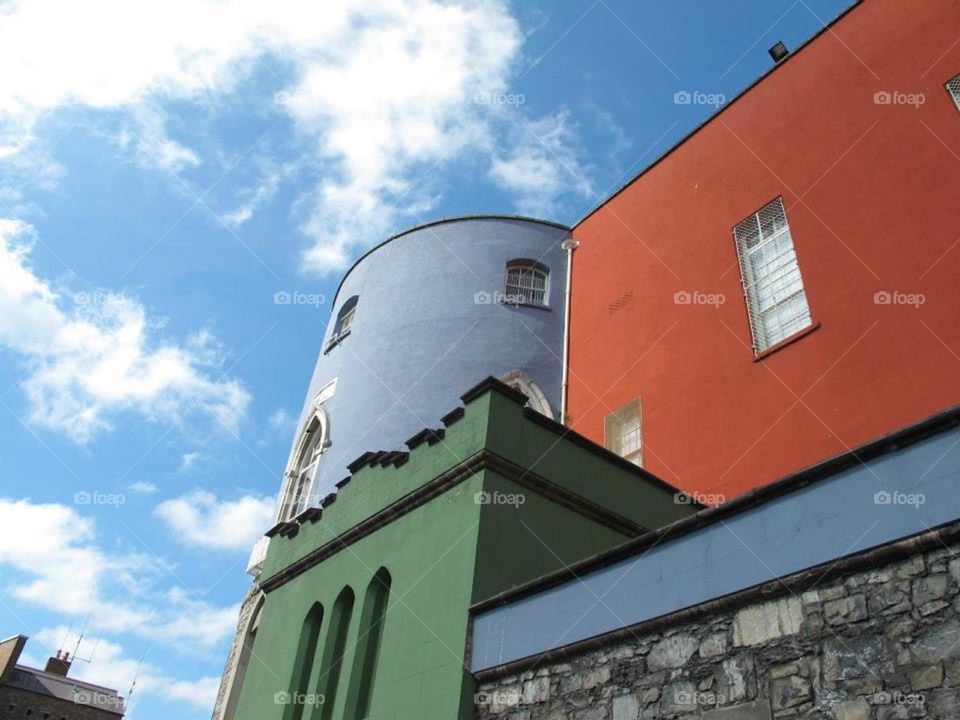 Colourful building in Europe - blue green and orange  against a clear blue sky 