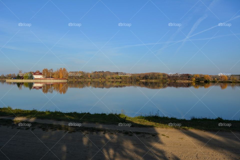 autumn beautiful landscape lake shore in the sunset light blue sky background