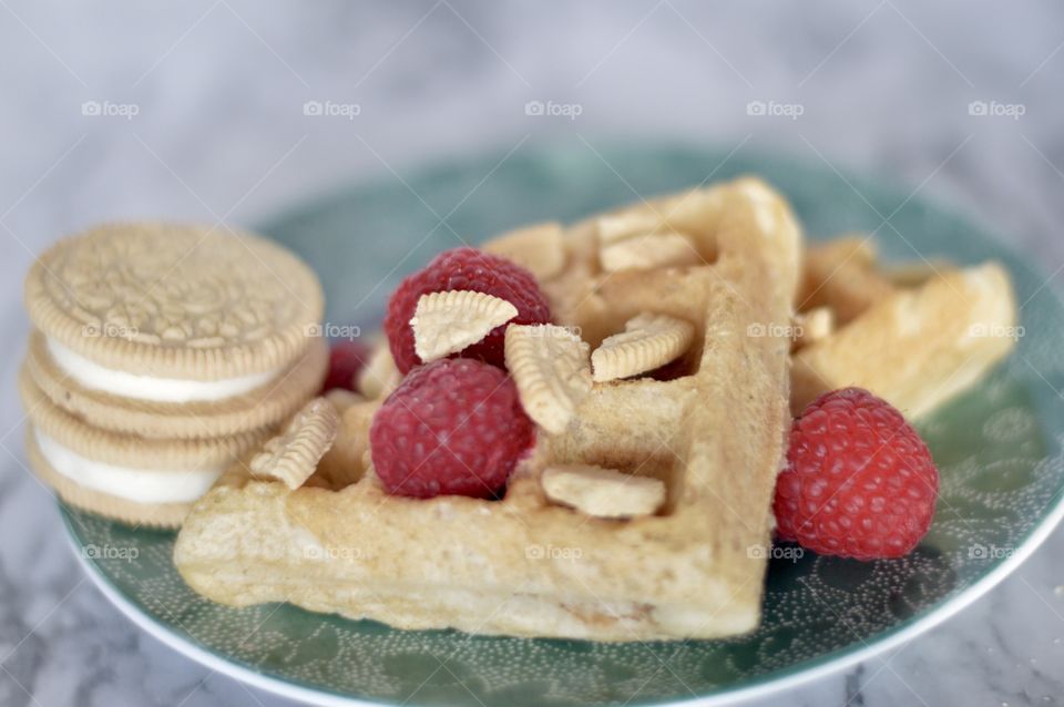 Golden double stuff Oreo cookies and a waffle with raspberries 