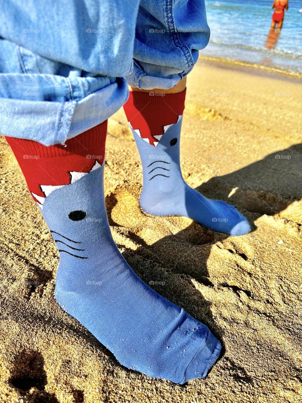 I’m standing in my Shark Attack socks with my pants although rolled up still on while a tan lady in a long distance swimmer’s bathing suit enters the mighty Pacific Ocean for a workout and yes there are sharks out there