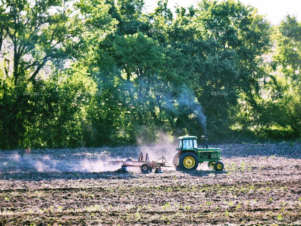 Green Color Story - green tractor discing in a field 