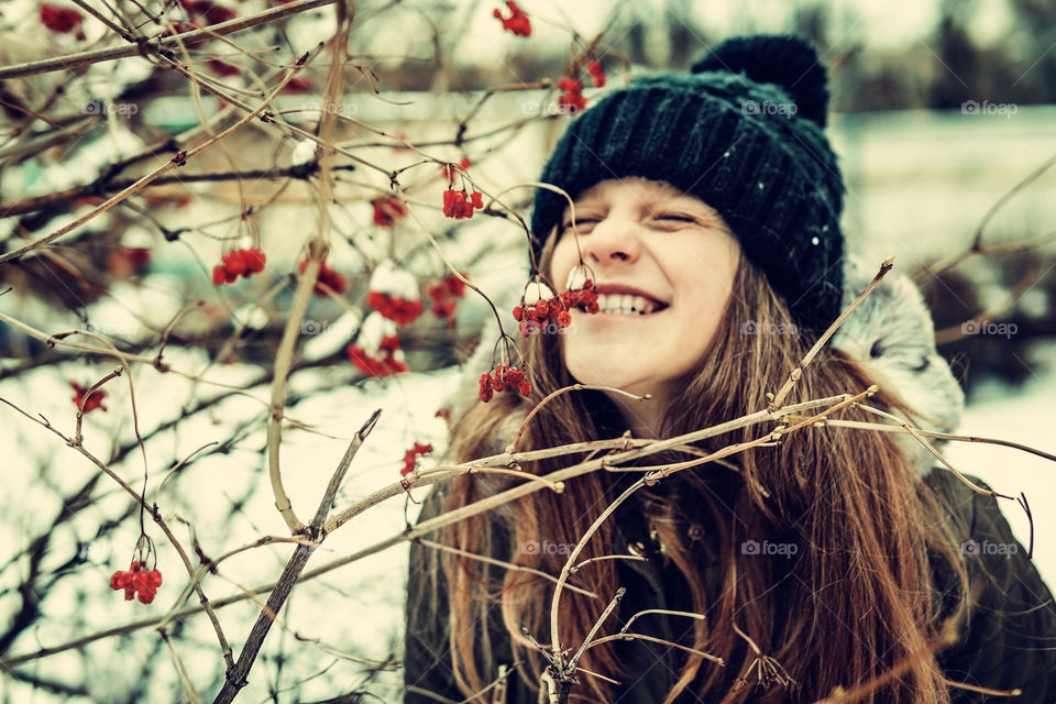 Winter has arrived. Portrait of a girl with snow berries and winter hat