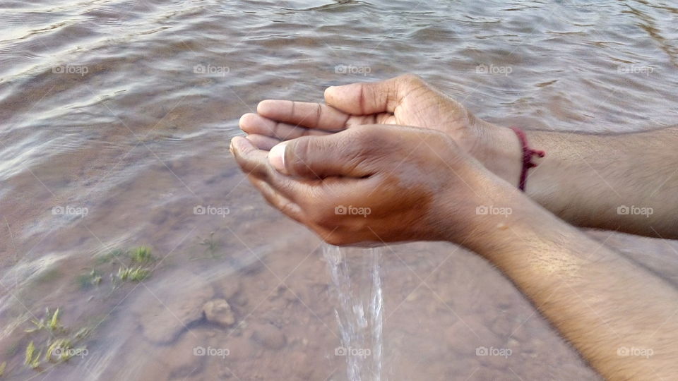 water falls down between two hands