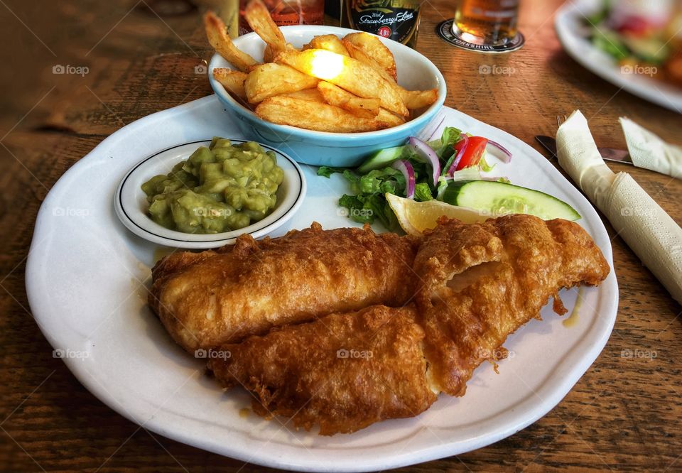 Posh fish and chips mushy peas and salad on a plate 