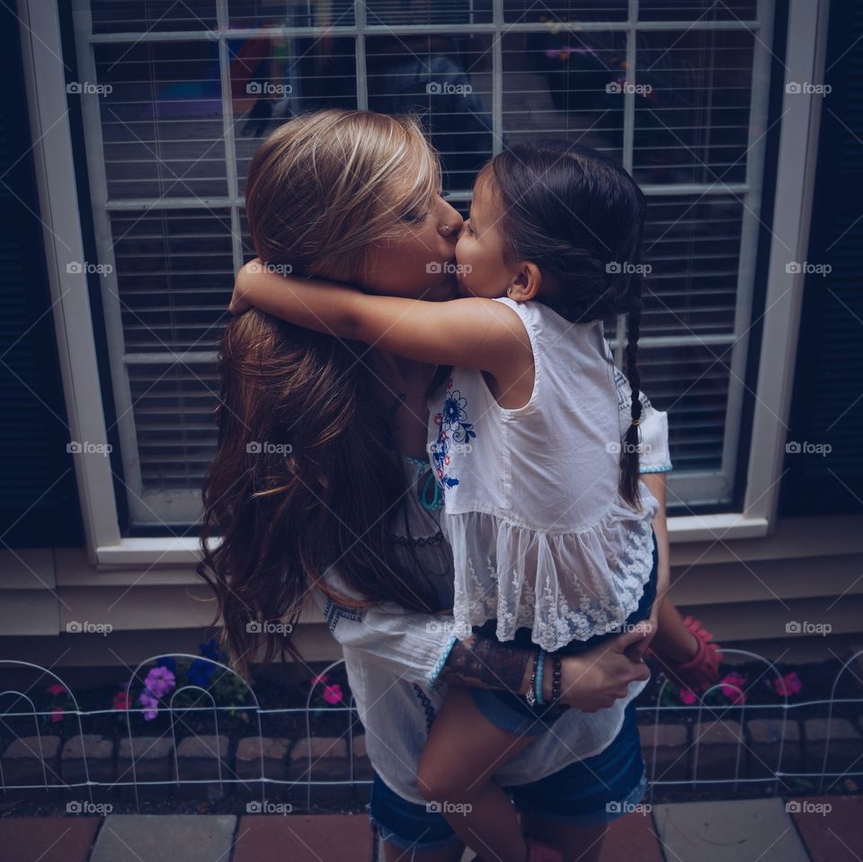 Mother and daughter kissing each other