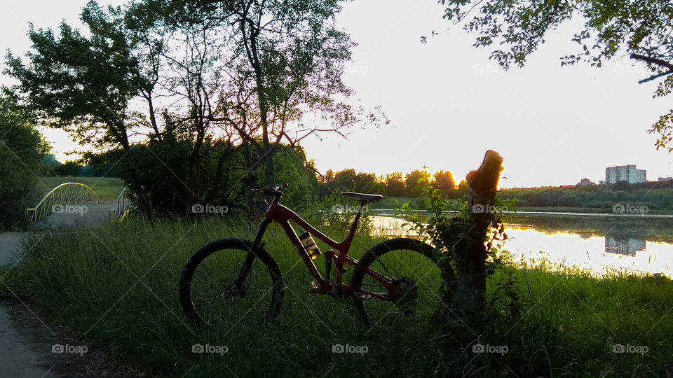 Bicycle and sunset on the lake shore