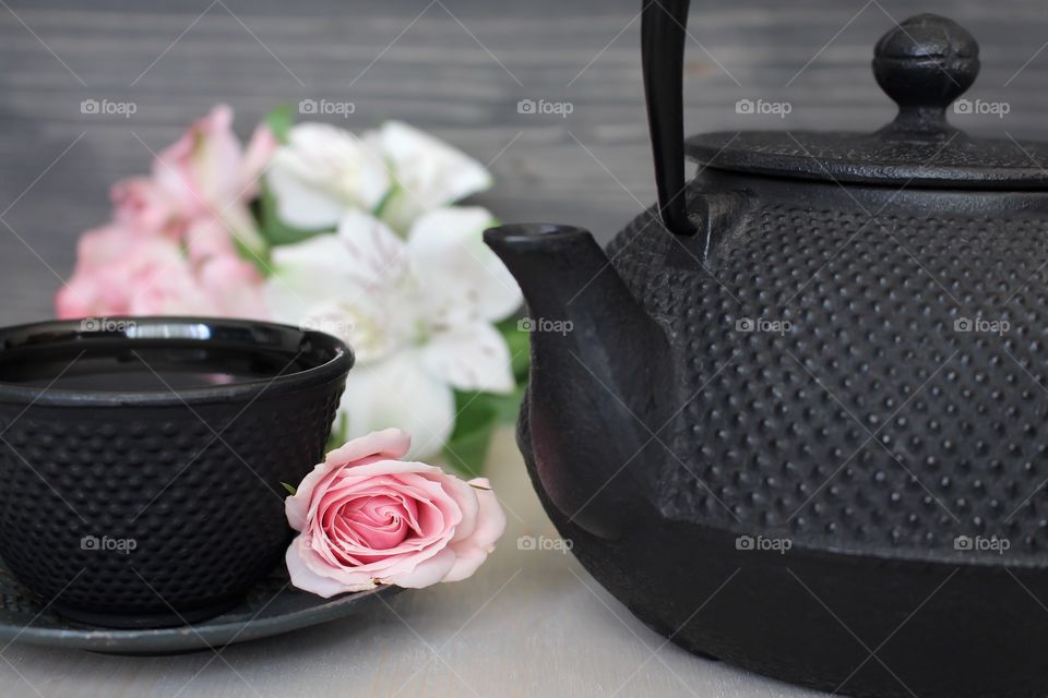 Cup of black tea with teapot
