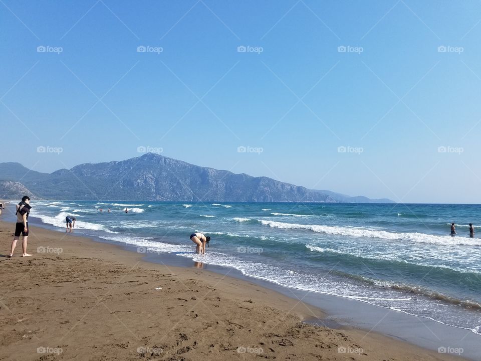 a beach in fethiye turkey, mountains in the background