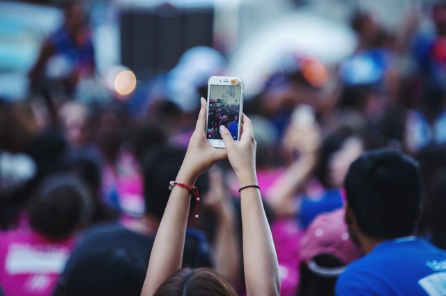 A young woman taking pictures on her phone