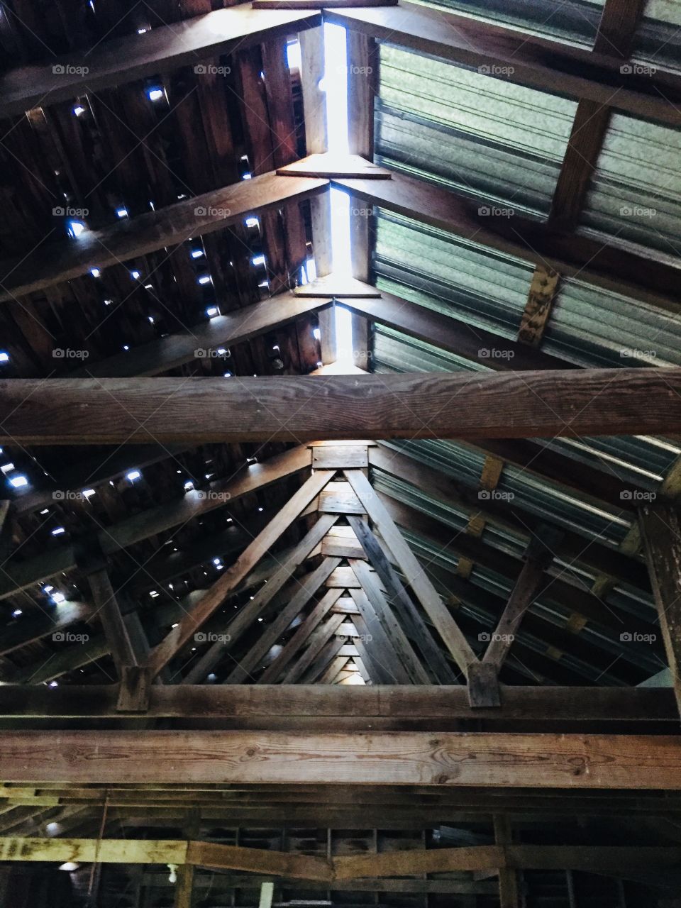 Interior view of rafters, trusses and roof of a partially restored vintage farm building, circa 1915