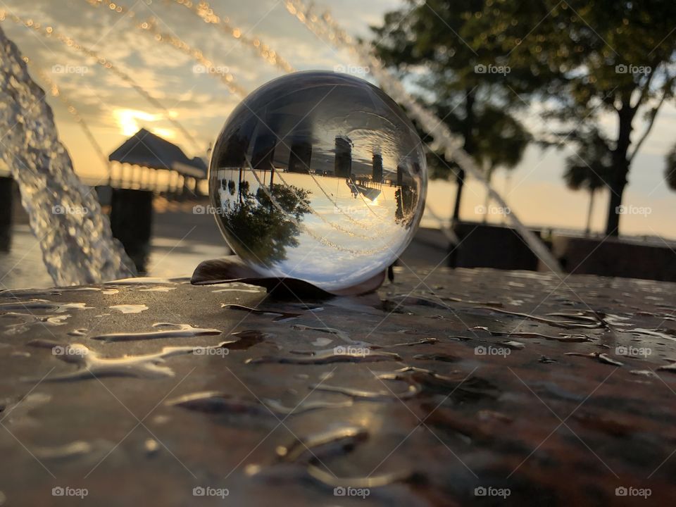 Crystal ball view of beautiful waterfront park fountain 