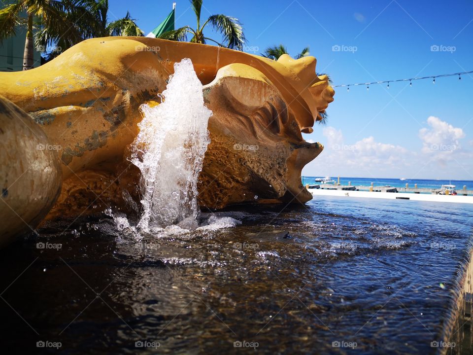 fuente de un coracol mujer, fusión un tanto perturbadora pero bellísima, donde el dorado con negro crean un gran contraste con el cielo y mar azules del malecón