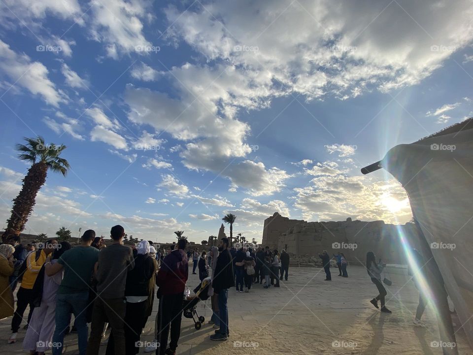 The sun tries to spread its rays through the clouds in a warm day at Karnak temple in Luxor 