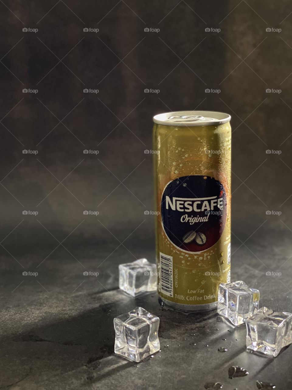 Closeup of Nescafe can drink with ice cube on the side.