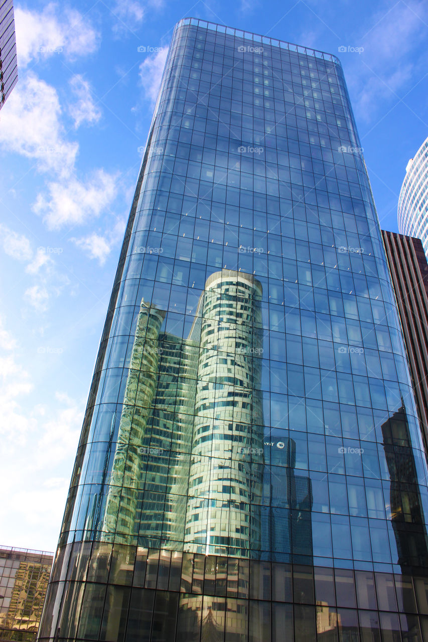 Skyscraper mirrored on a modern skyscraper Made of glass