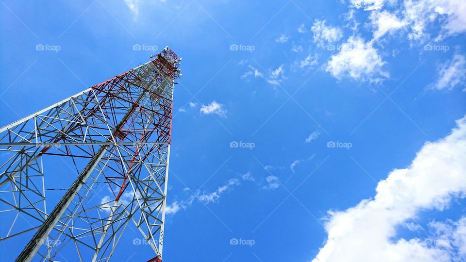 Tower of mobile phone network on blue bright sky background