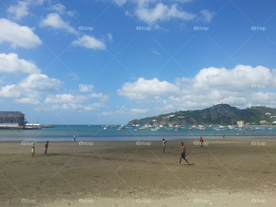 summer day and boys playing baseball at the beach