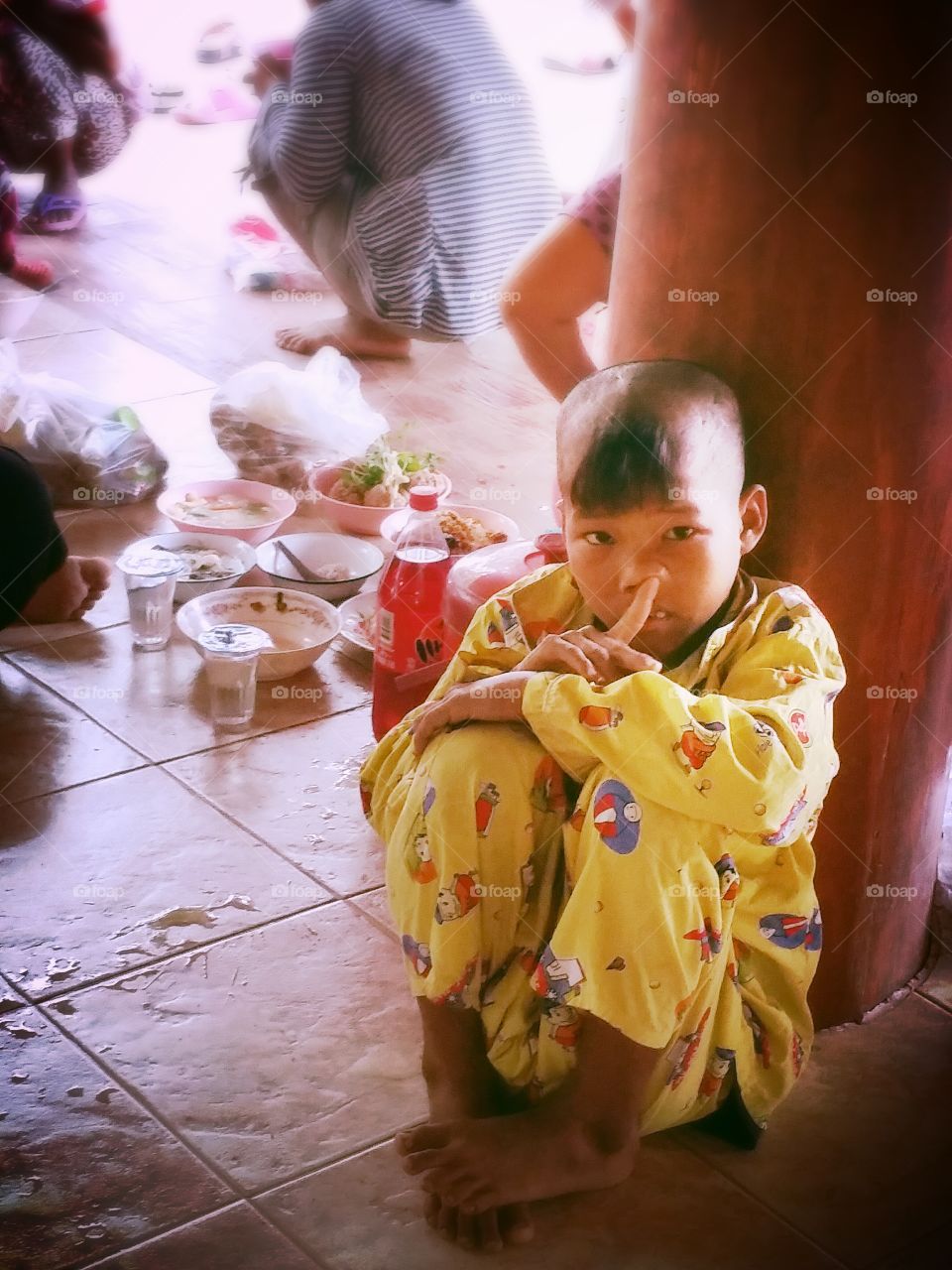 A boy.. A boy is sitting on floor.