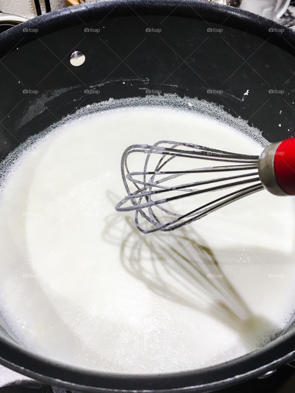 High angle view of whisking milk