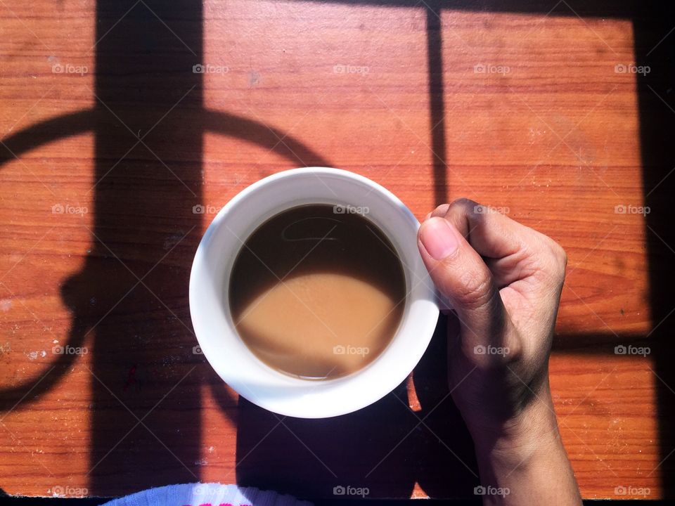 A hand holding a cup of coffee