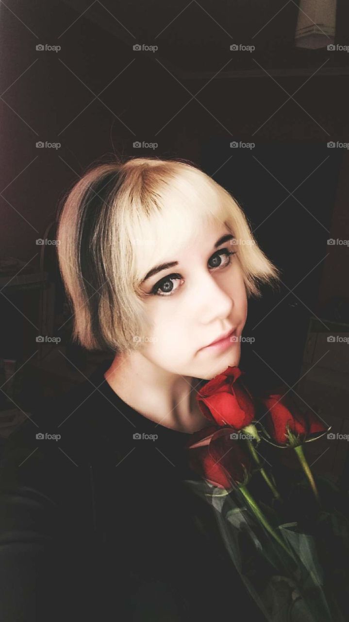 girl blonde young schoolgirl spring flowers selfie dark background happiness joy spring women's day sitting young fashionable hairstyle roses beautiful face eyes black red burgundy