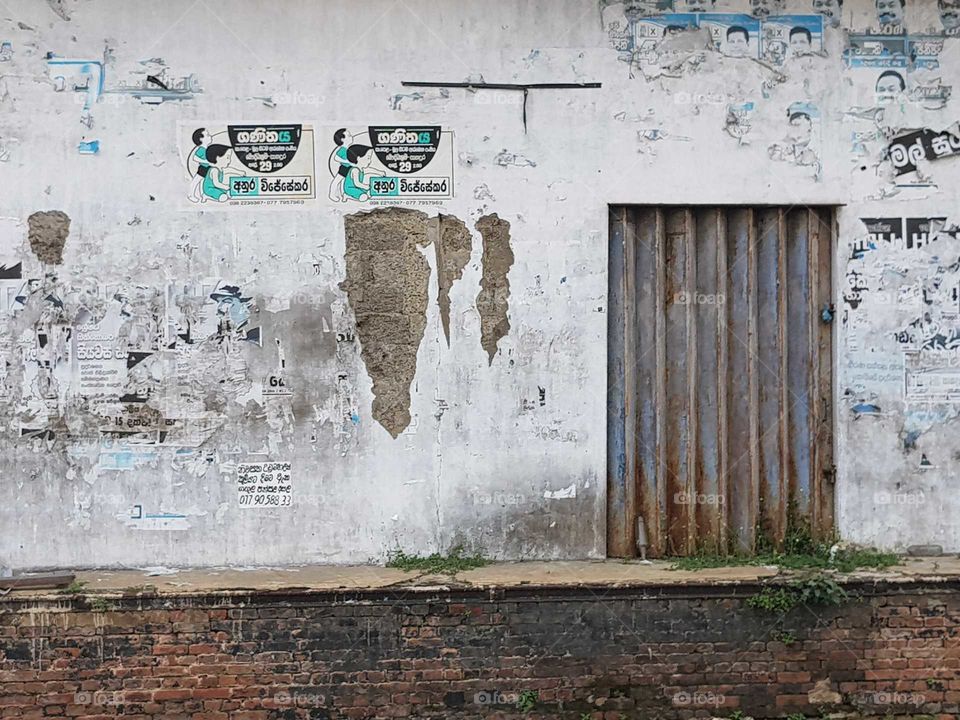 Urban art and ruined posters at an old building adjoining the Railway Station in Panadura Sri Lanka. Damaged by the 2004 Tsunami in the Indian Ocean.