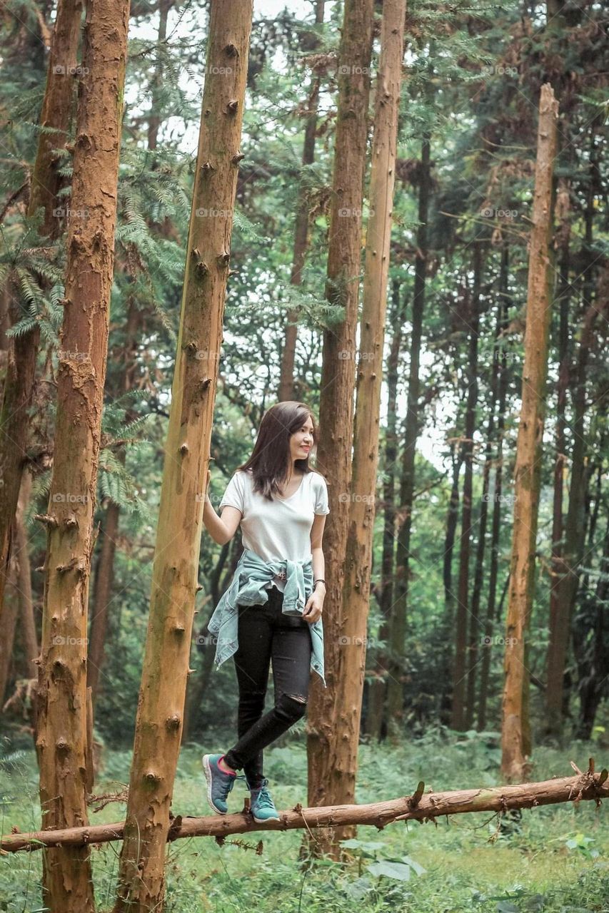 Happy girl enjoying life and freedom in the forest. The forest is beautiful and forest are vital to life on Earth.