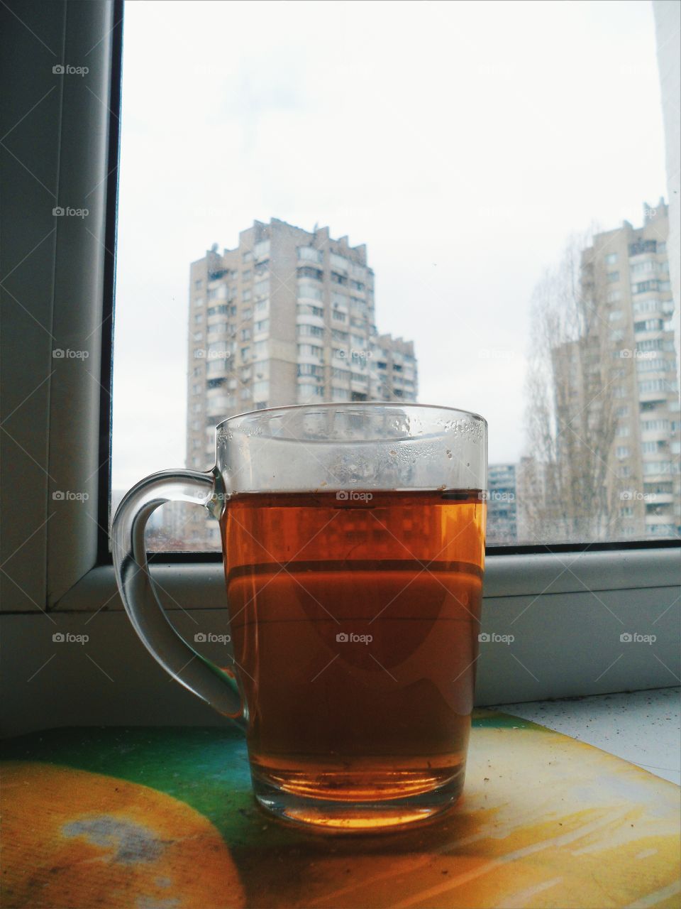 cup of black tea stands on the windowsill