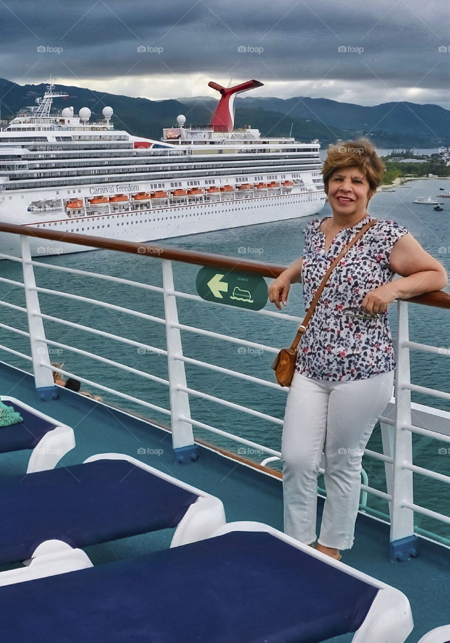 Happy woman standing on deck in cruise