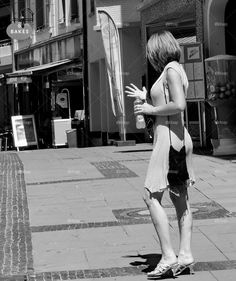 A beautiful woman in a dress shops the cobbled streets of Europe on a lovely day. 