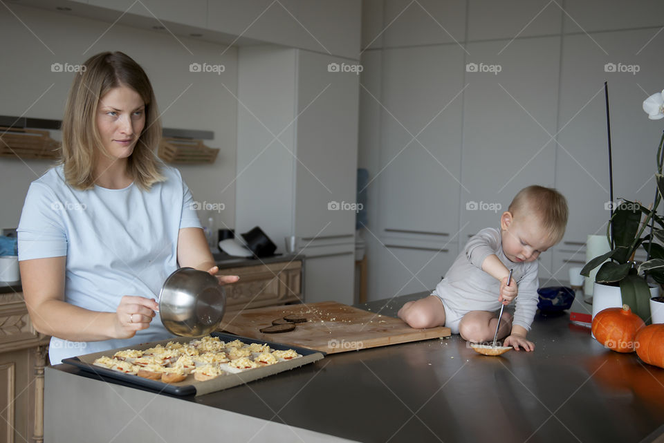 Mother and baby making cheese breads in the kitchen