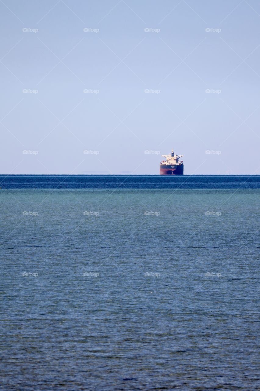 Cargo ship anchored on horizon 