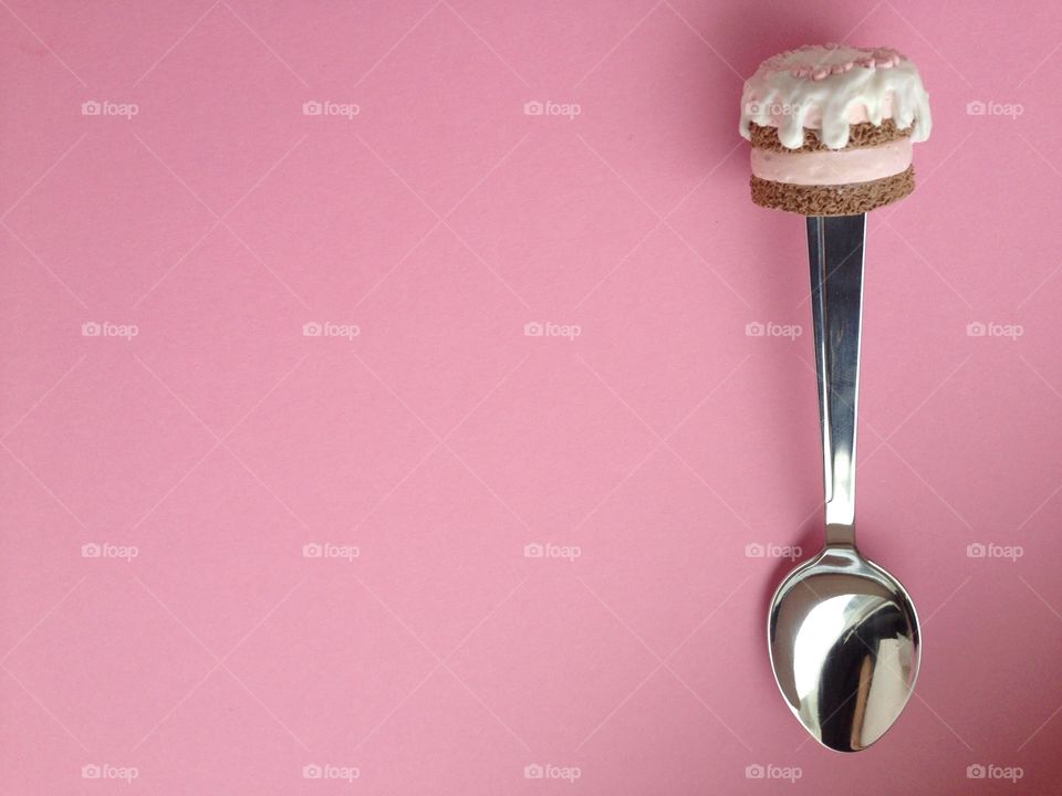 spoon with cup cake on pink background