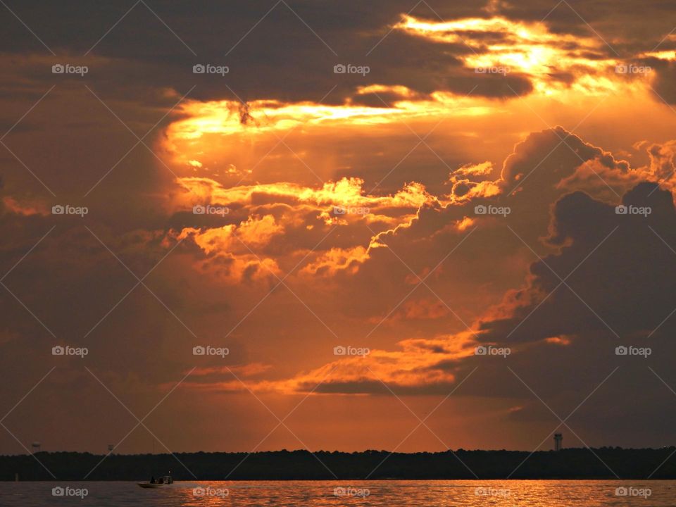 It was sunset. I watched with an unwavering gaze, as a fiery orange orb of light slowly sank beneath the horizon, and threads of light lingered in the sky, mingling with the clouds