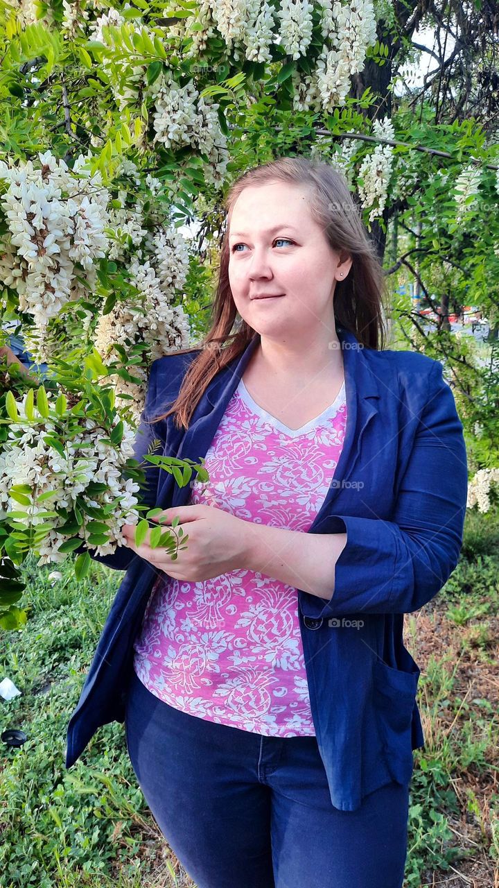 Woman in blue and pink near the blossom acacia